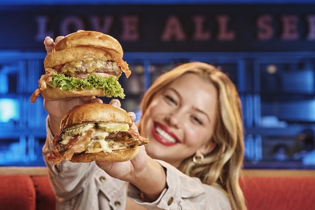 a woman holding two burgers