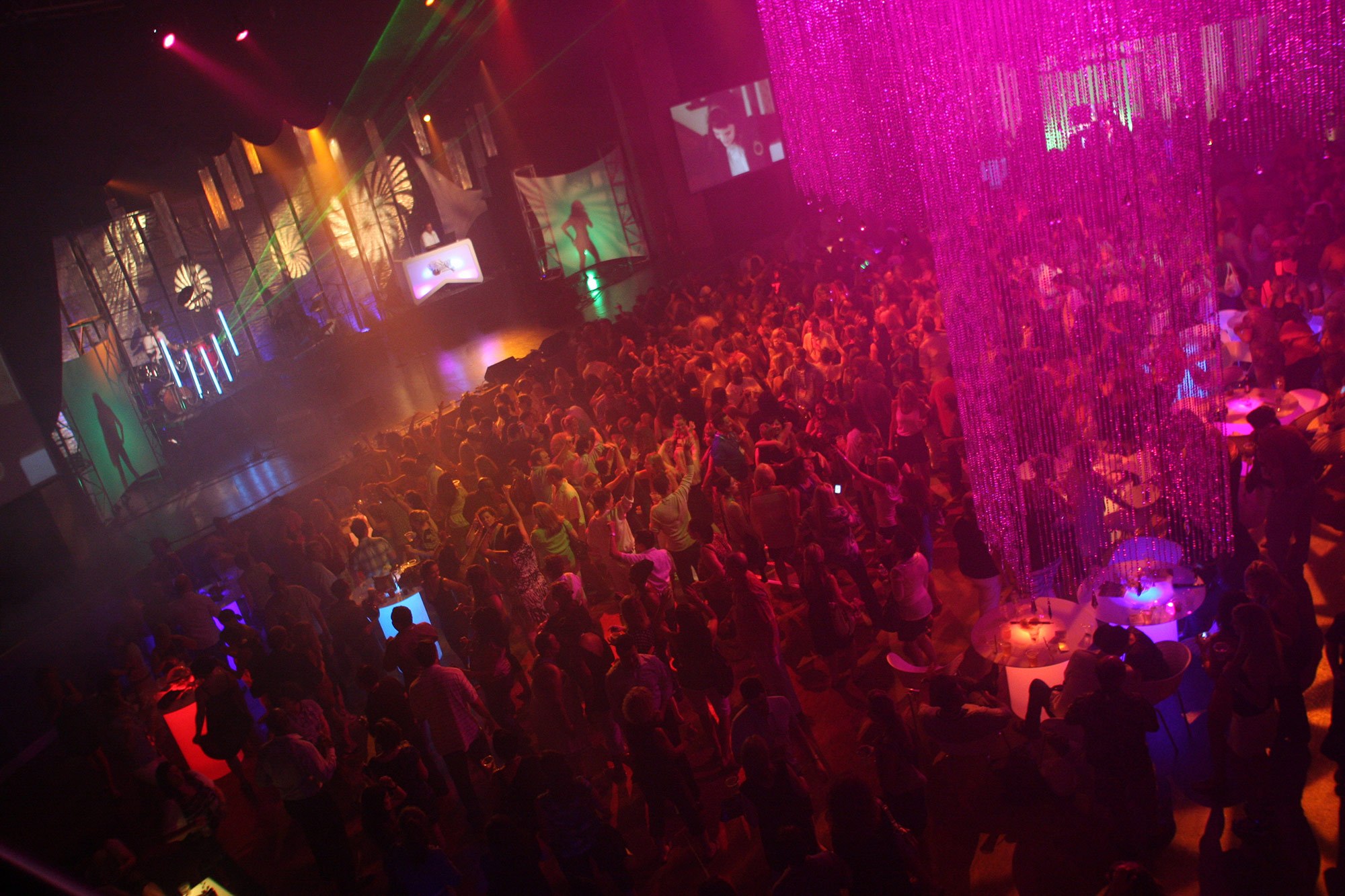 a crowd of people in a room with a stage and lights