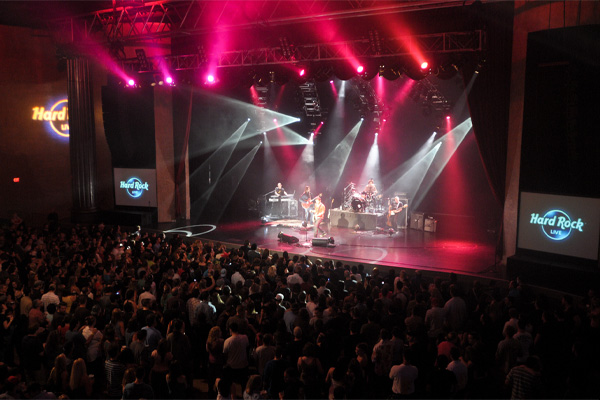 a band performing on stage with a crowd of people watching