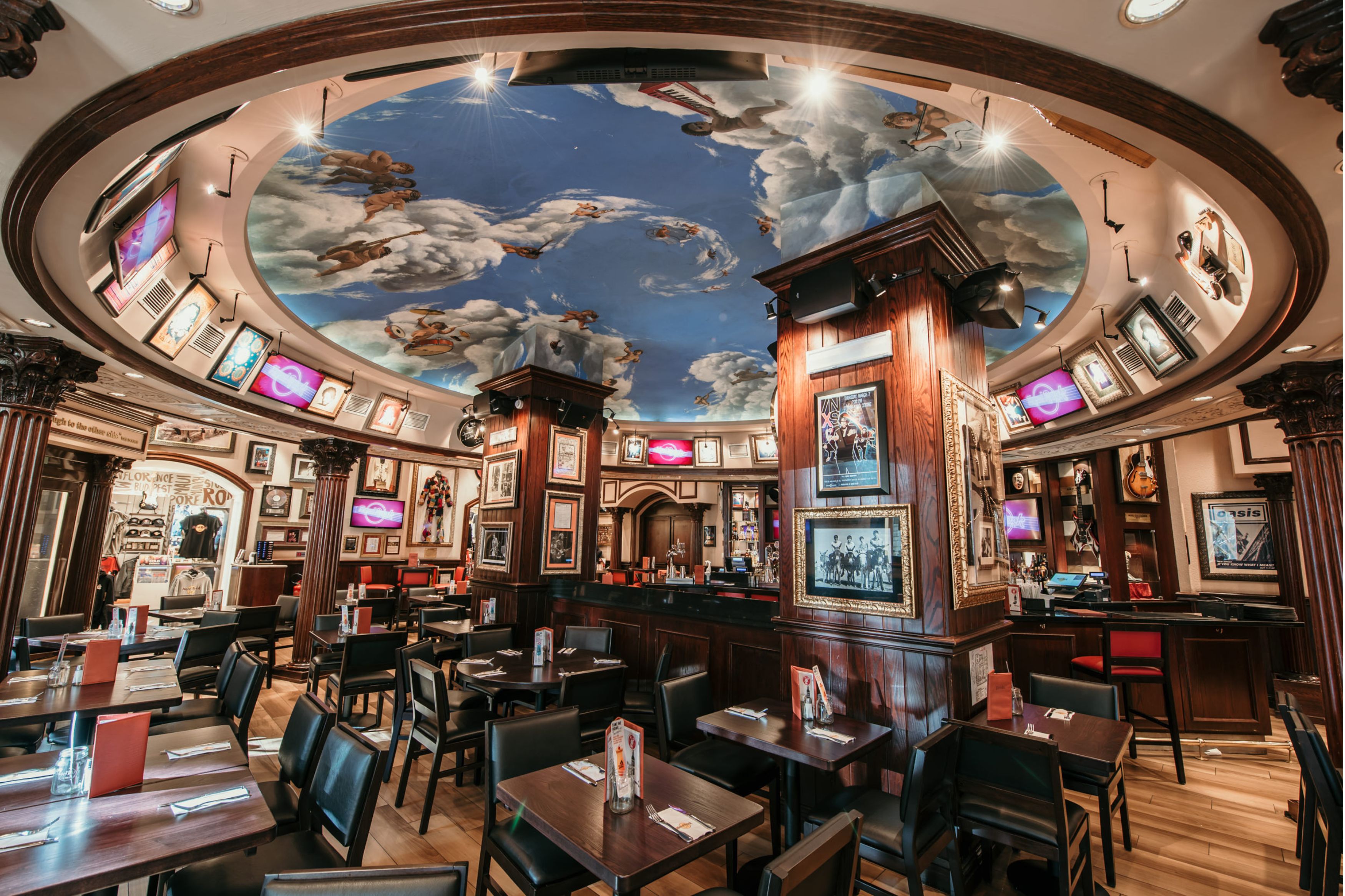 a room with tables and chairs and a ceiling painted with pictures