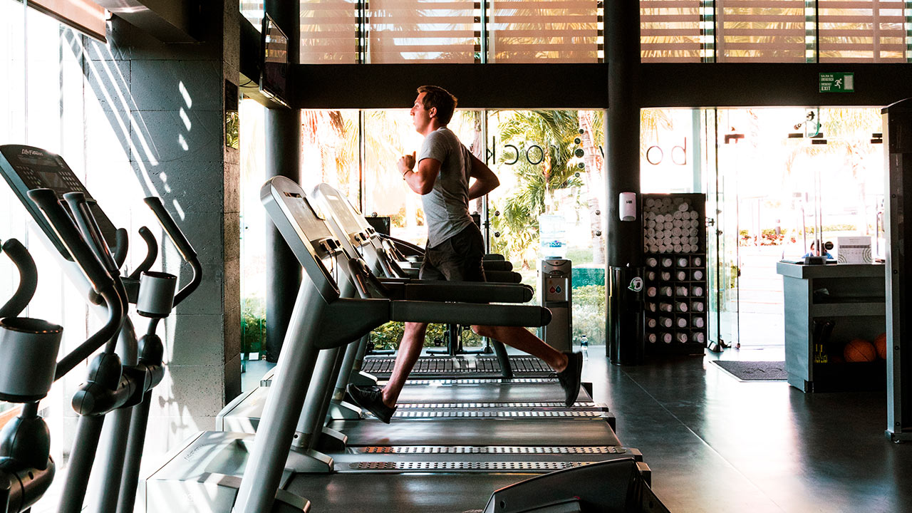 a man running on treadmills in a gym