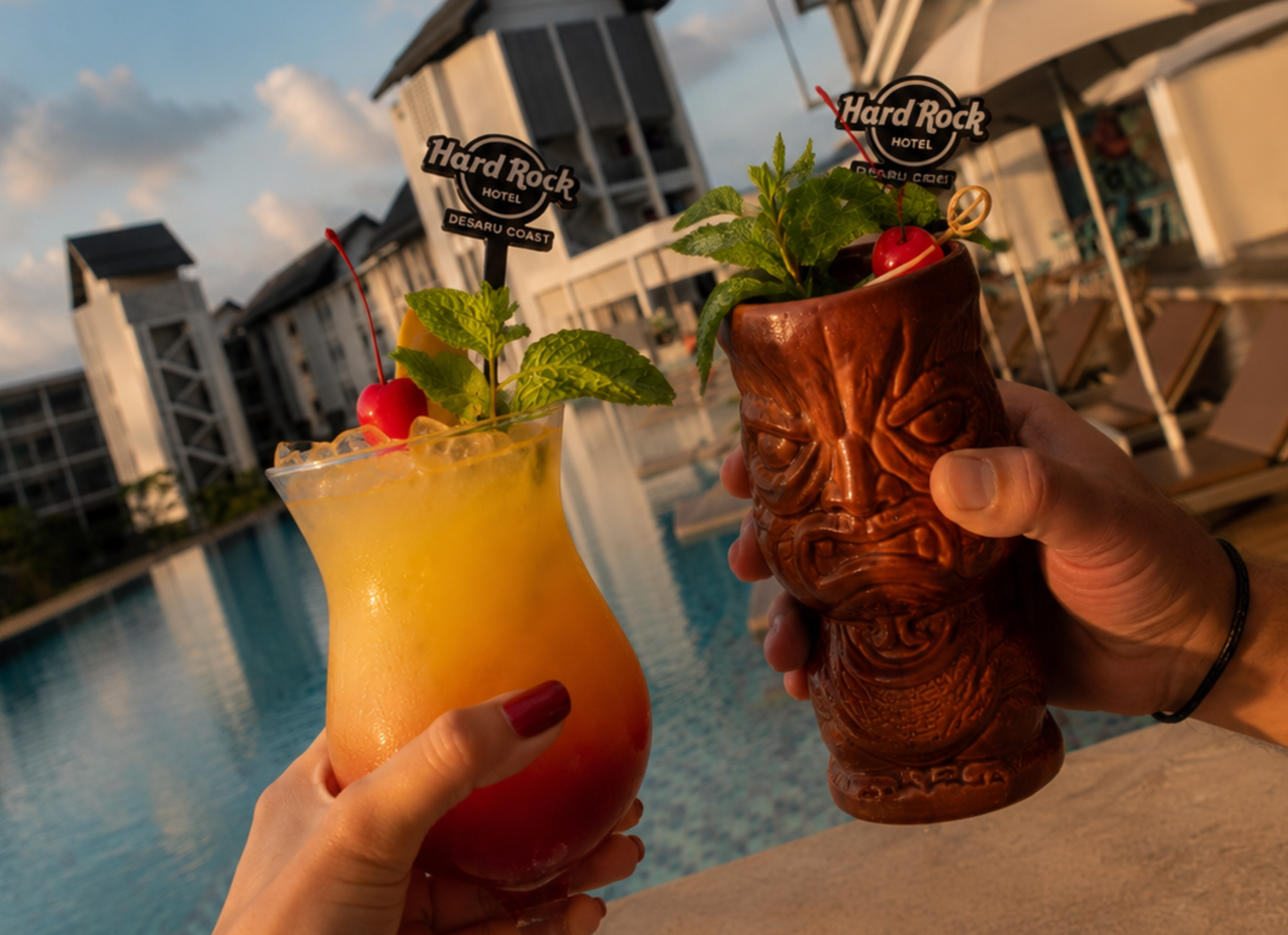 a couple of hands holding drinks