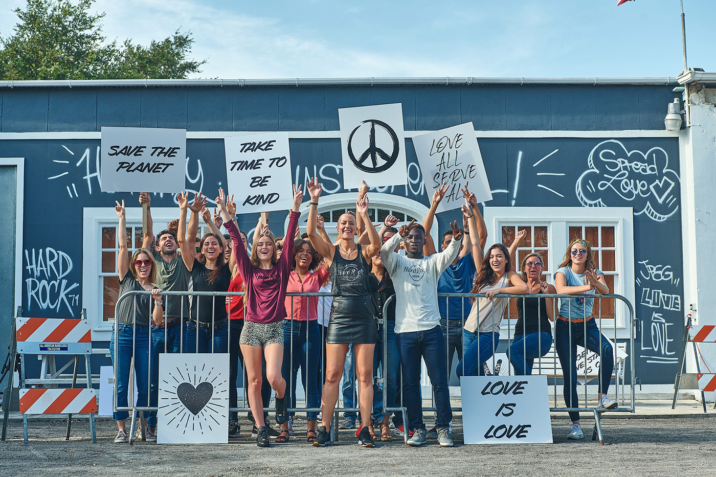 Crowd of people holding signs featuring Hard Rock's mottos