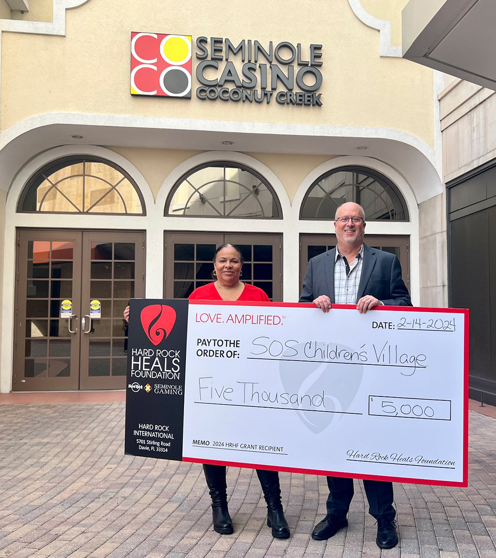 Seminole Casino Coconut Creek presents a large check donating 5 thousand dollars to charity.