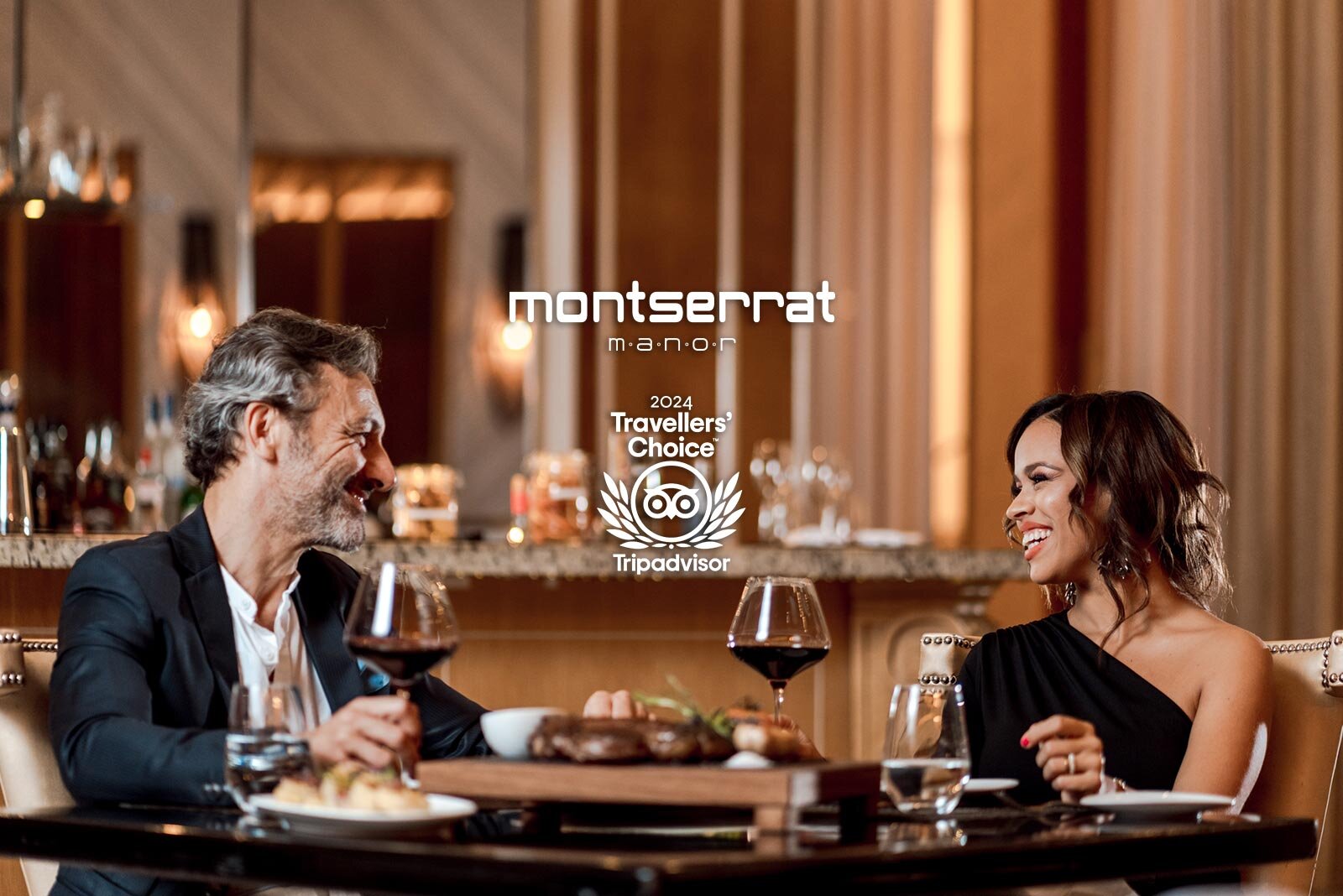 a man and woman sitting at a table with food and wine glasses