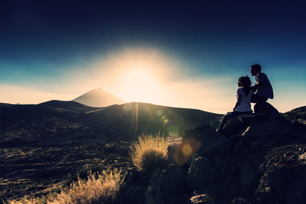 couple hiking and watching the sunset
