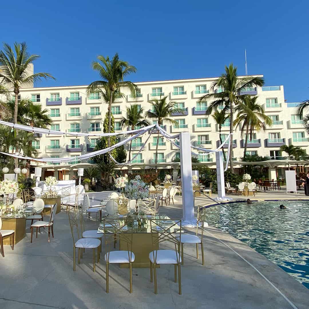 a pool with tables and chairs and palm trees