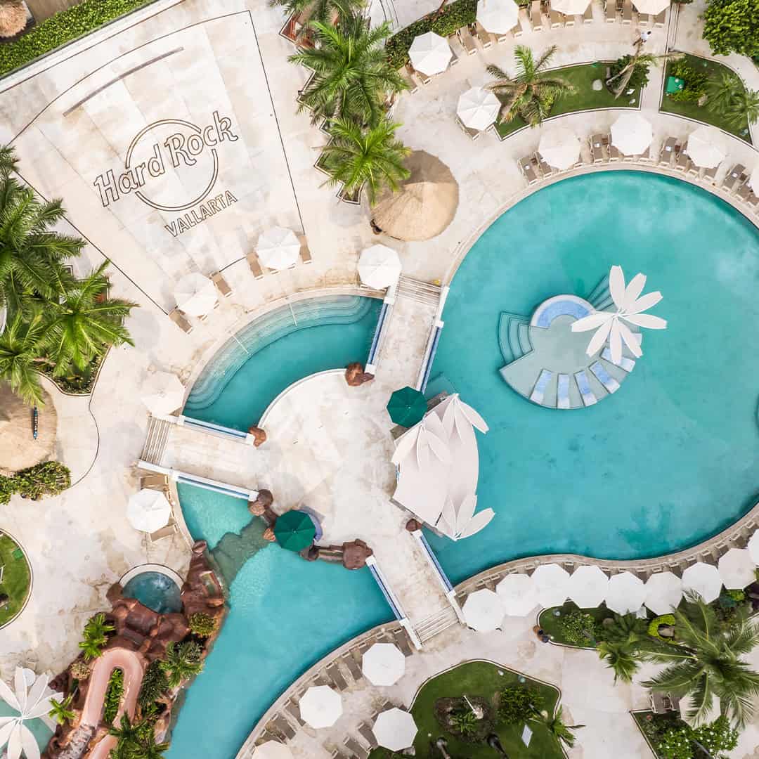 a swimming pool with umbrellas and palm trees